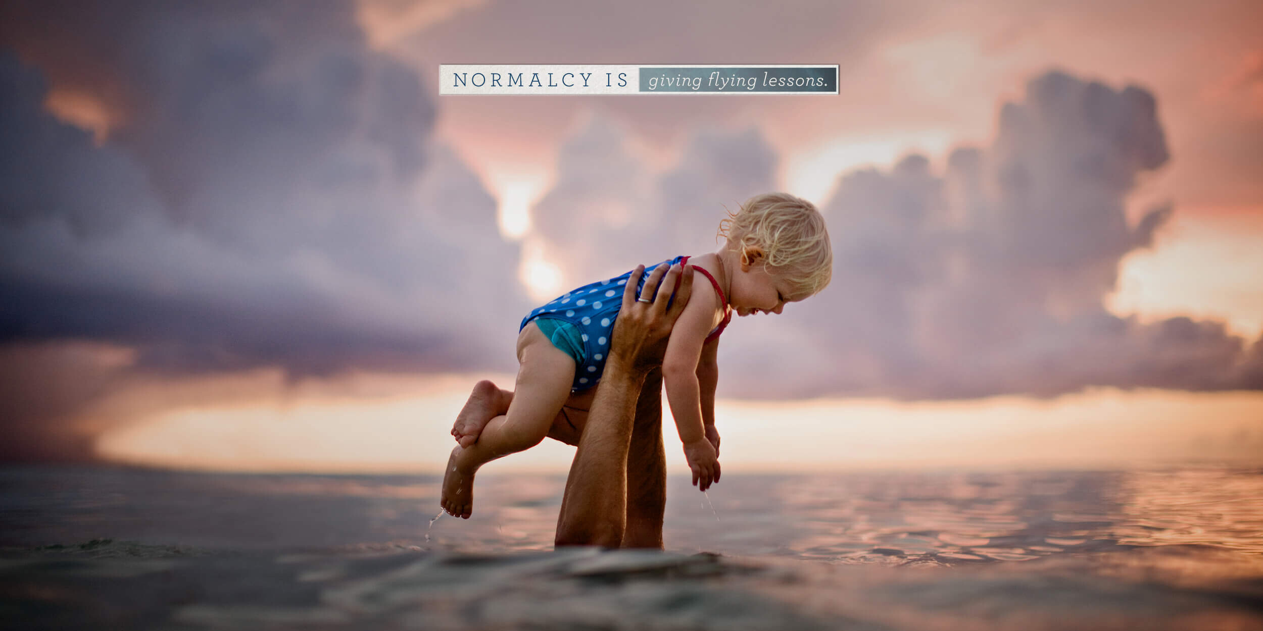 North American spine hands holding baby above water