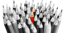 red pencil in field of grey pencils