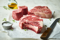 Steaks with olive oil salt and steak knife for butcher's mark