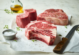 Steaks with olive oil salt and steak knife for butcher's mark