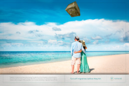 Couple standing on beach with a safe flying towards their heads
