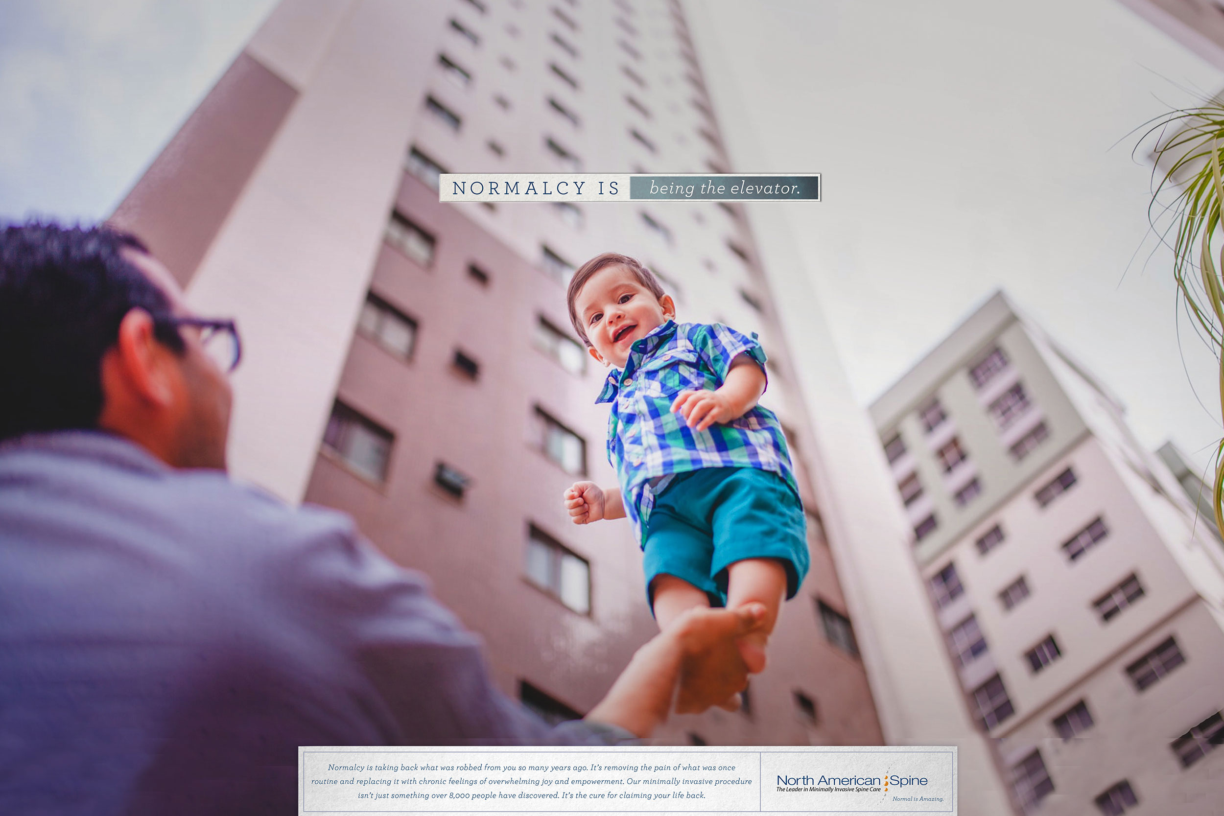 man holding baby up ad for North American spine institute normalcy is being the elevator
